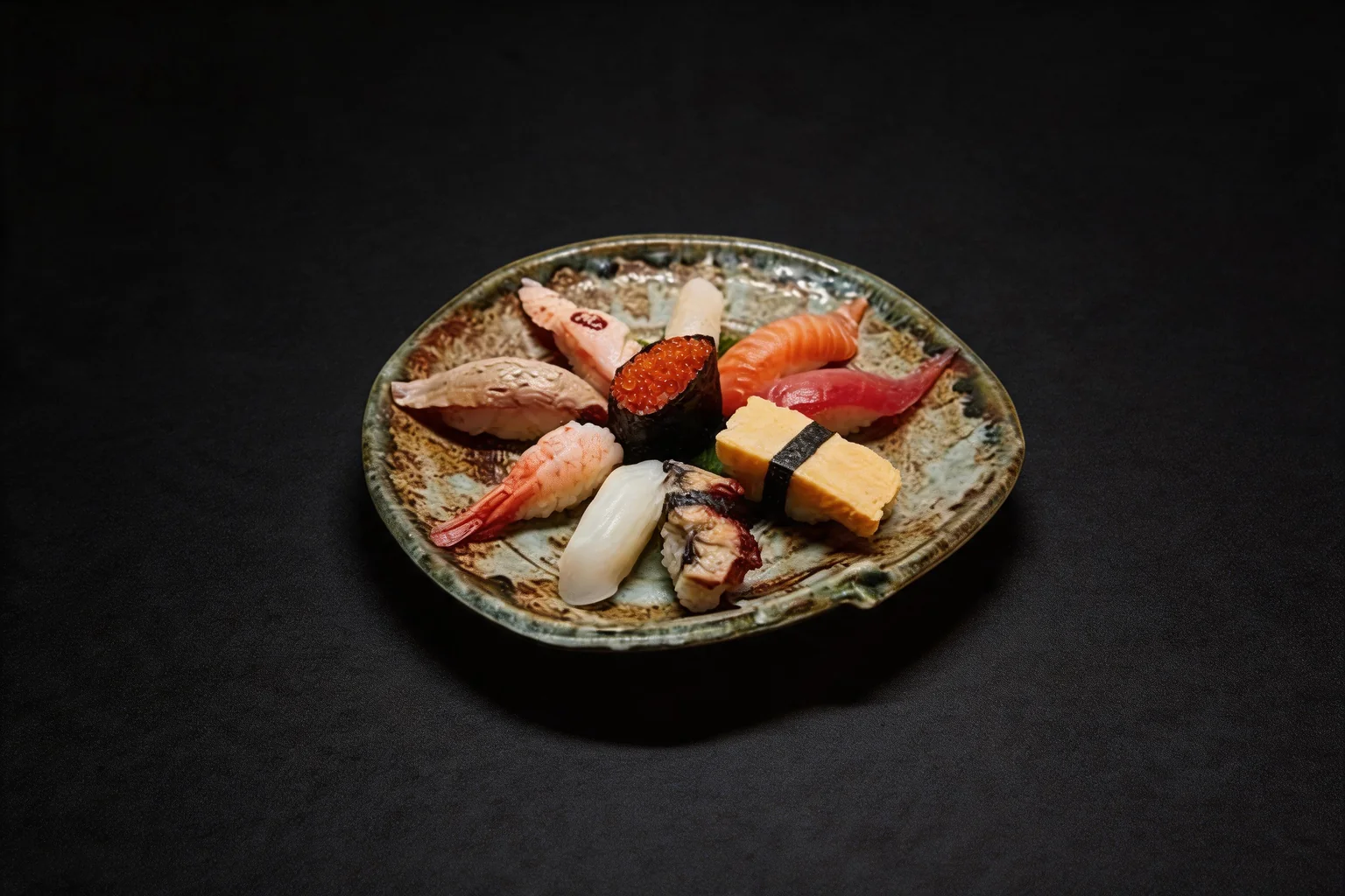 Sushi set: sushi on a round ceramic plate, dark background.